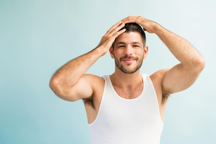 portrait-attractive-smiling-muscular-man-with-hands-hair-while-grooming-against-turquoise-background (1)