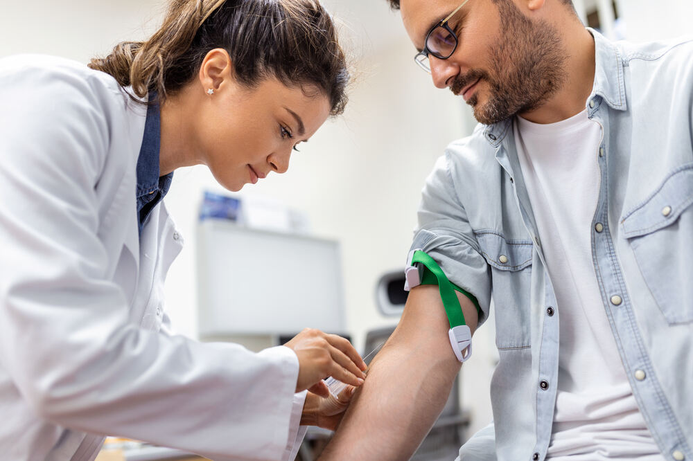 friendly-hospital-phlebotomist-collecting-blood-sample-from-patient-lab-preparation-blood-test-by-female-doctor-medical-uniform-table-white-bright-room-1.jpg