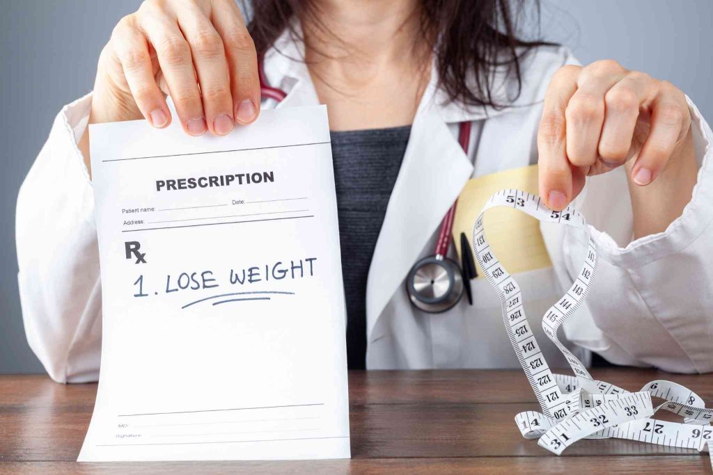 Doctor holding lose weight prescription and measuring tape