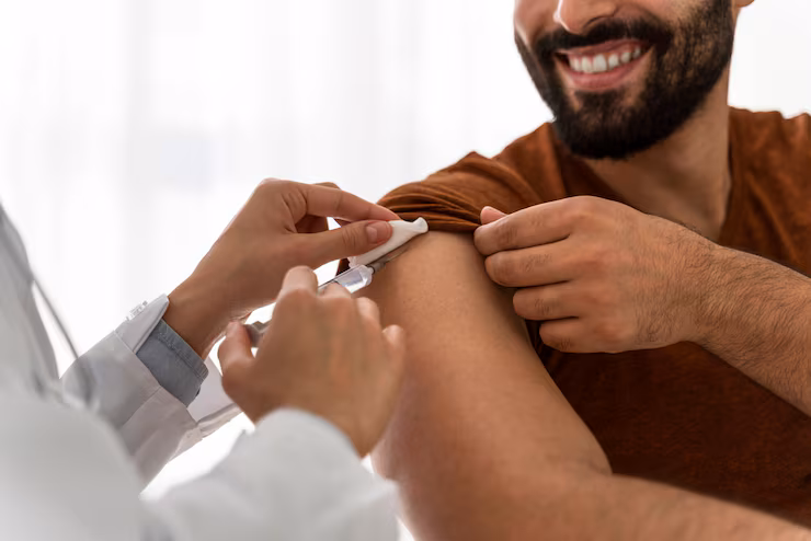 Doctor injecting a treatment to a male patient