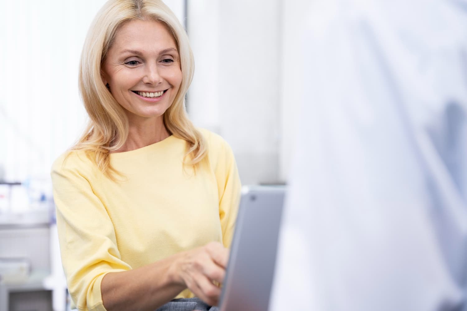 Middle-aged woman in a clinic, smiling during a consultation
