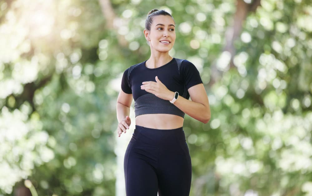 Smile fitness or happy woman running in park training cardio exercise