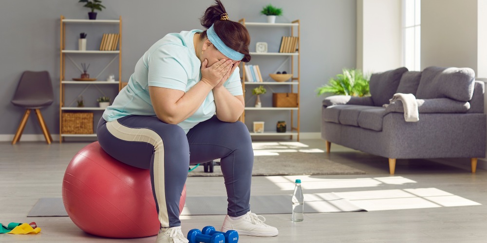 a woman sitting on a pink fitness ball in her living room