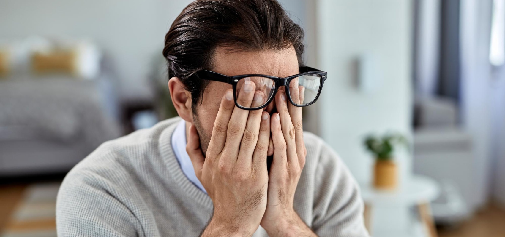 a man rubbing his eyes
