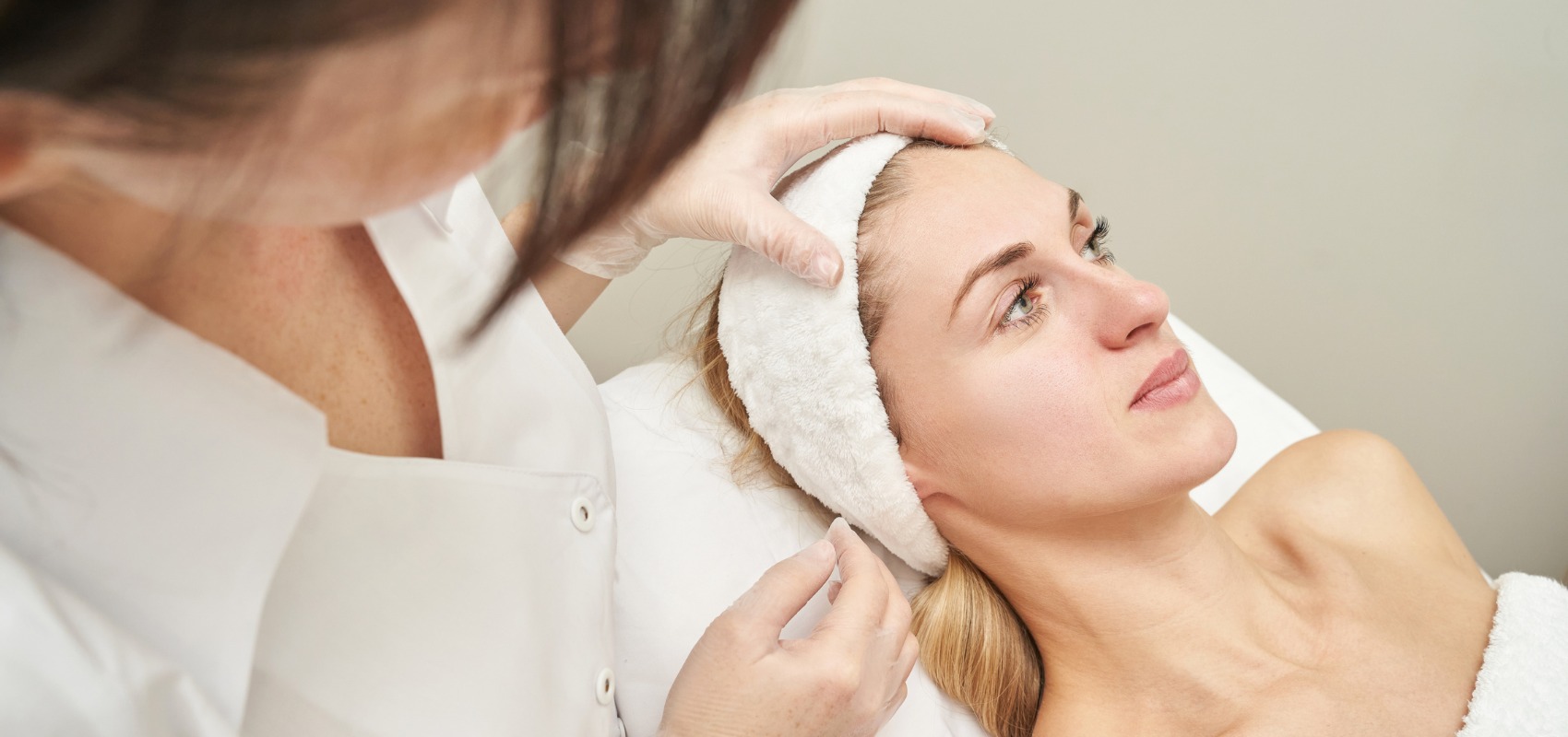 a doctor in gloved hands examines her face
