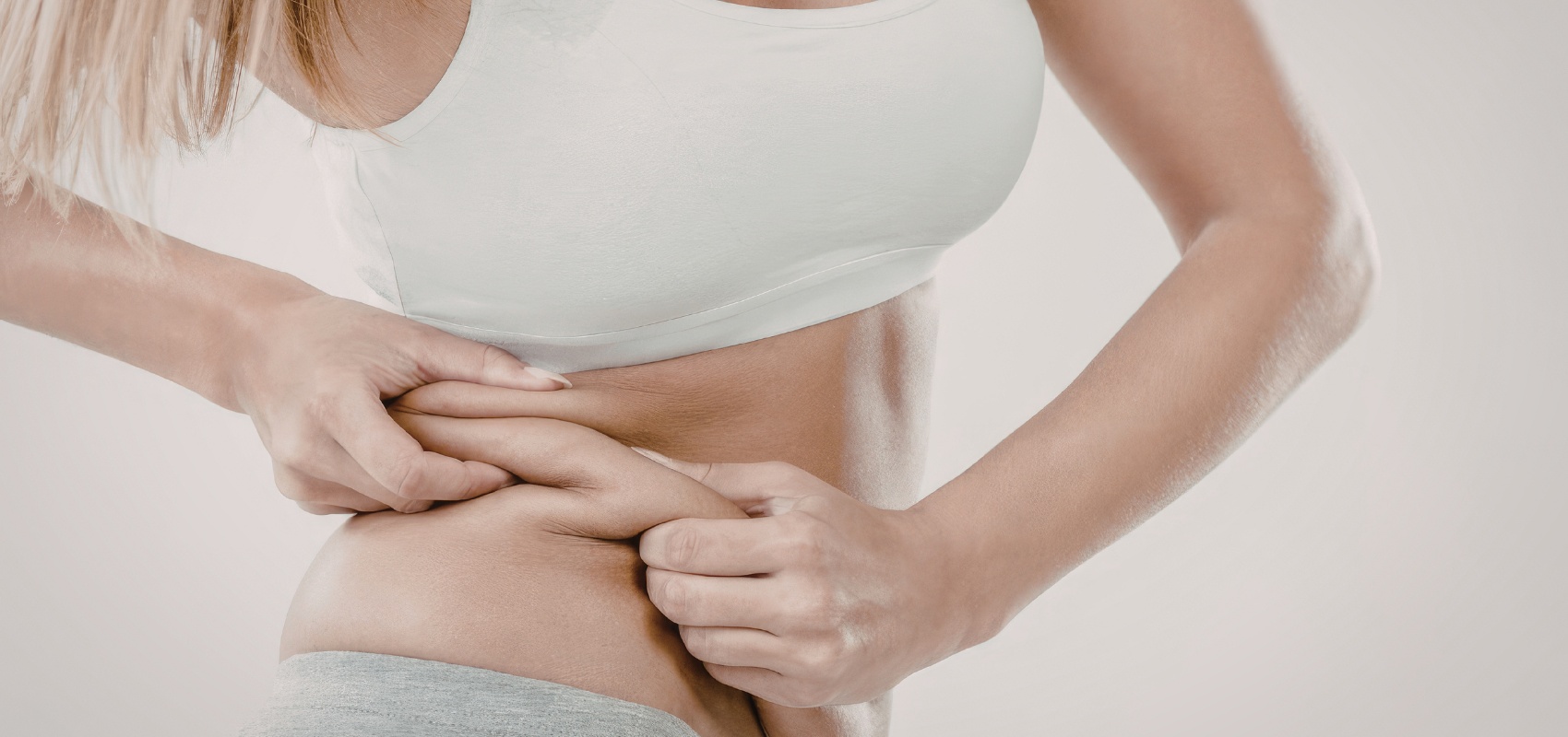 a woman pinching the skin and excess fat 