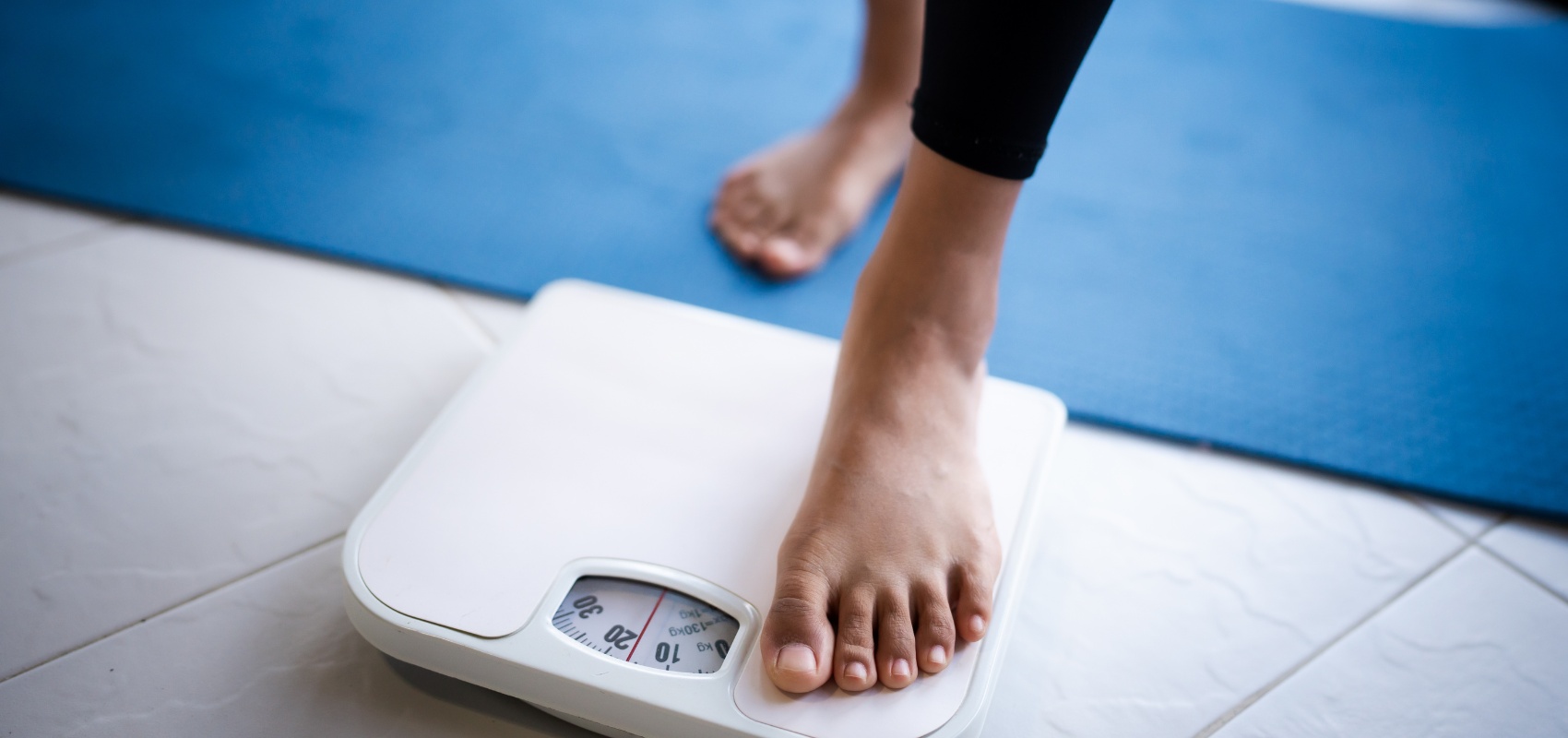 person stepping onto a white scale
