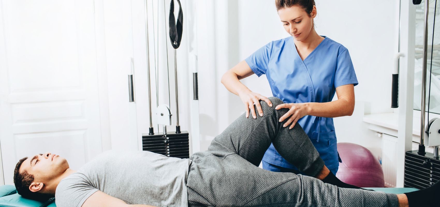 physical therapist examining a man's knee