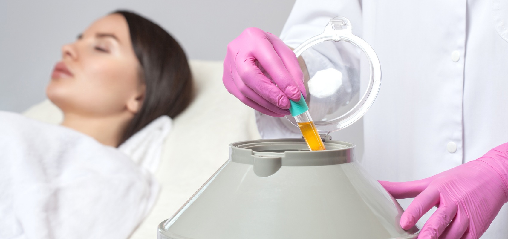 placing a test tube of yellow fluid into a centrifuge machine