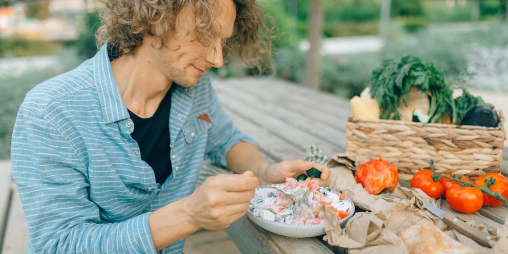 A young man eating a fresh salad