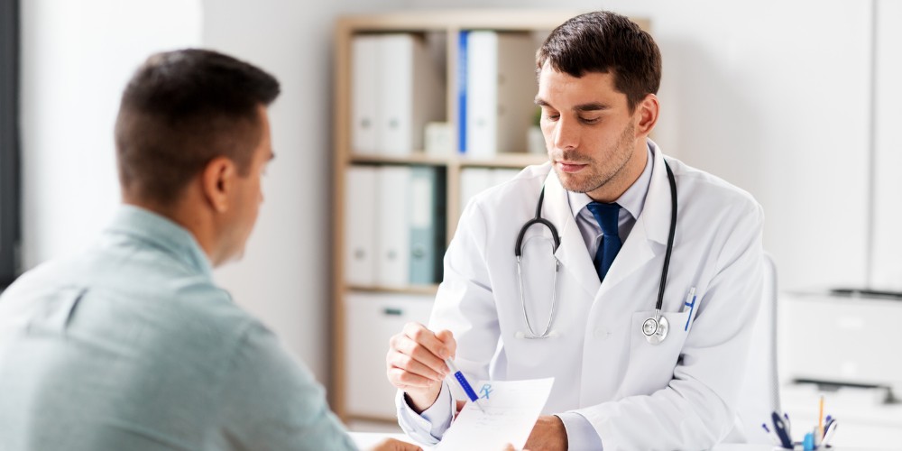 A doctor explaining a prescription to a male patient