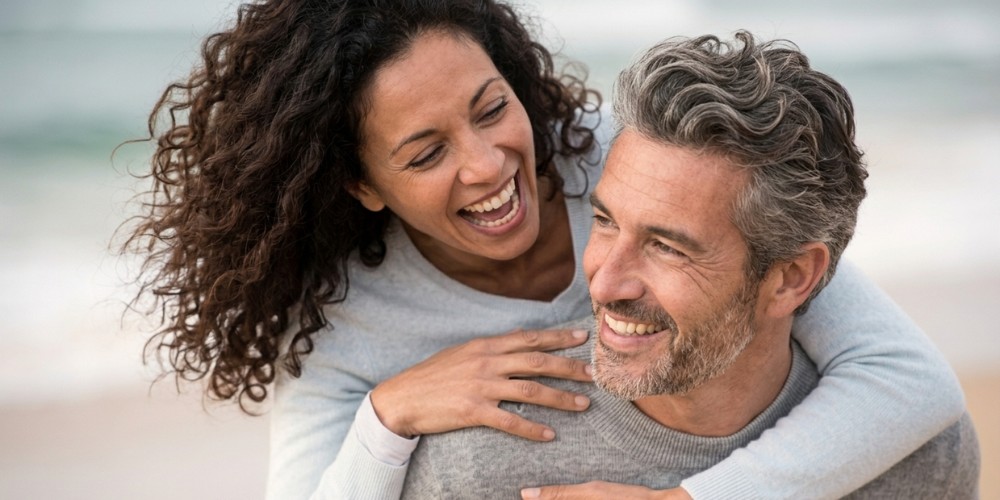 A happy, smiling middle-aged woman with a grey-haired man