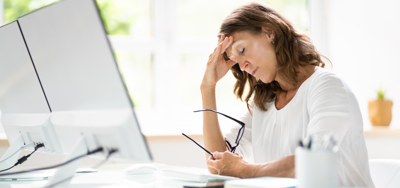 a stressed woman sitting at her office desk