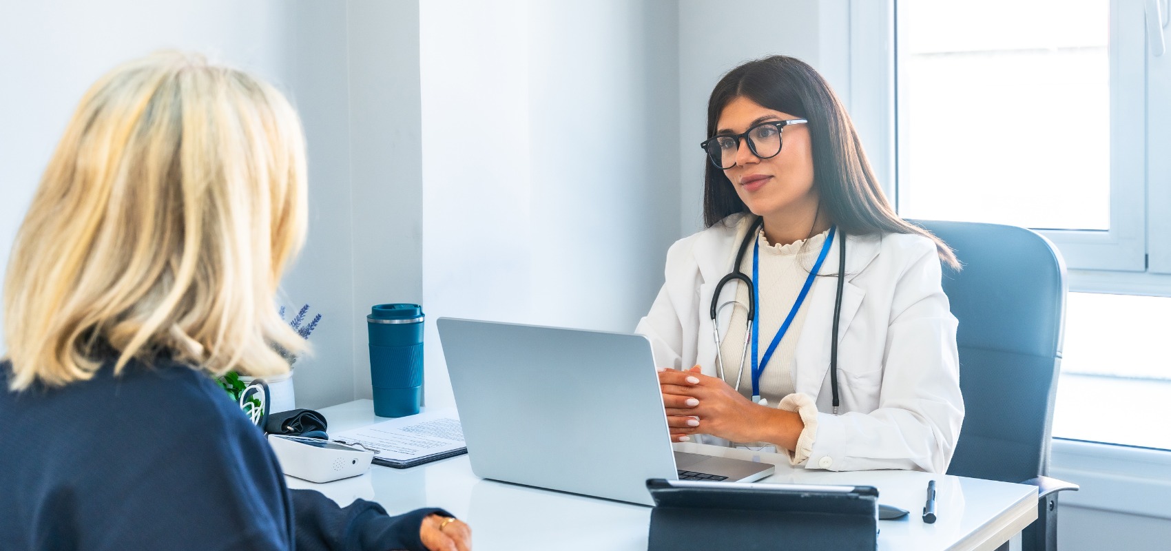 A female doctor listens attentively to a patient