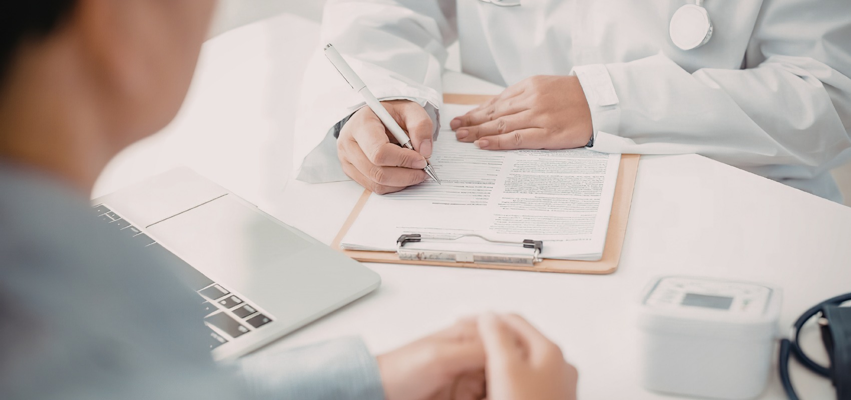 a doctor in a lab coat filling out paperwork