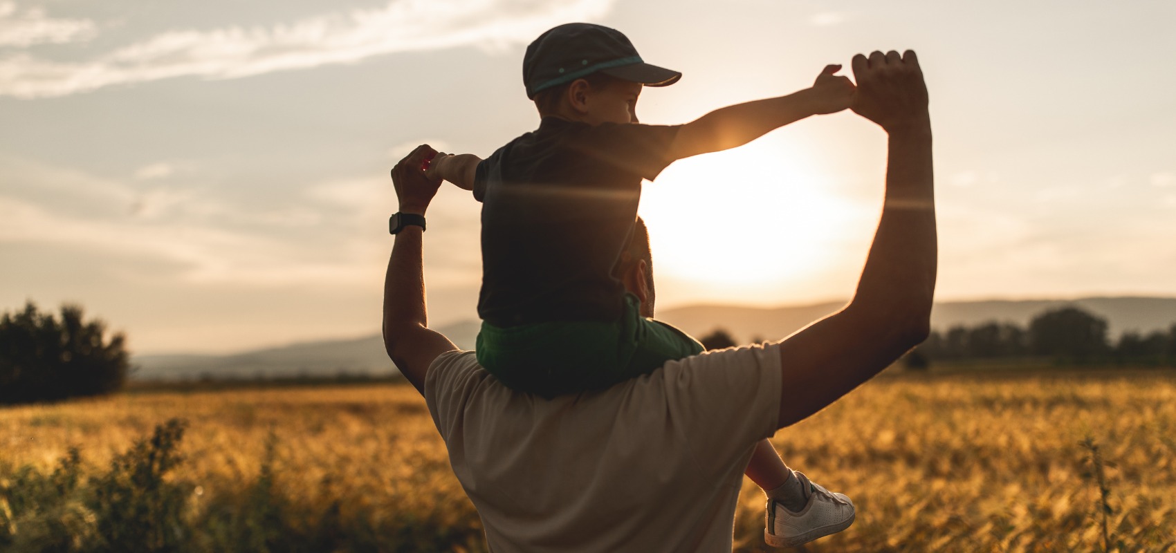 A father carries his young son on his shoulders