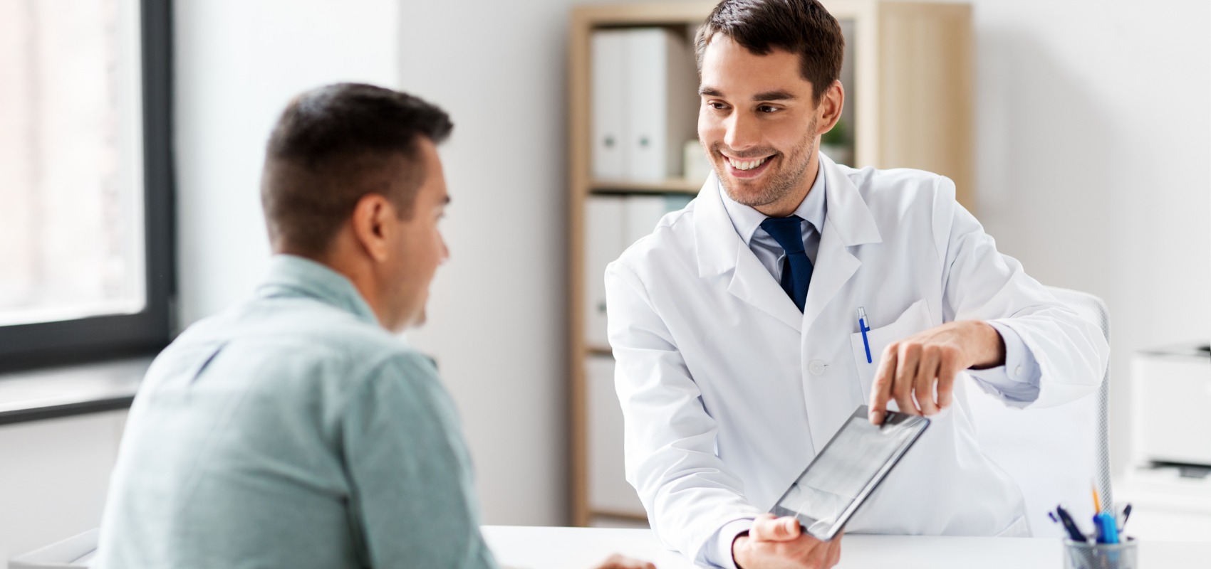 doctor shows information on a digital tablet
