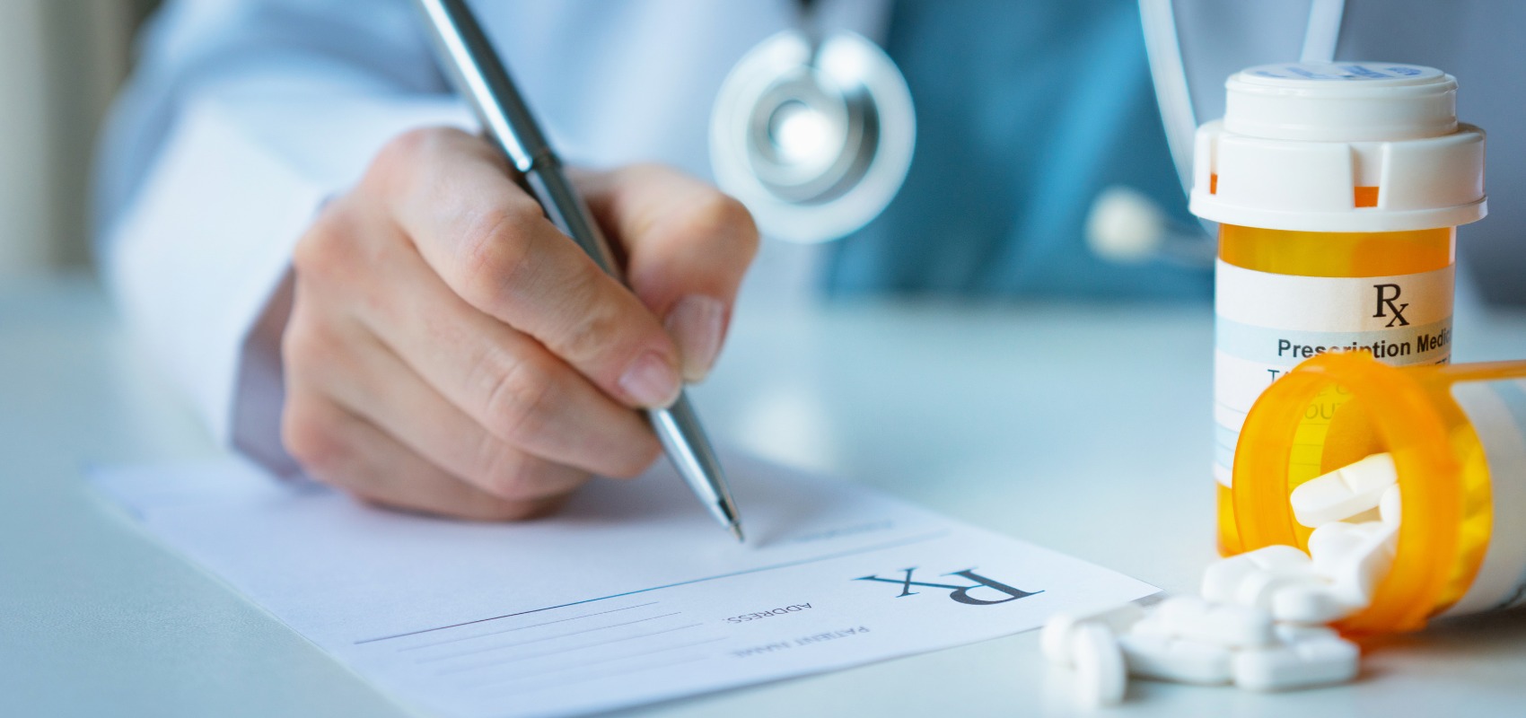 doctor writes on a prescription pad