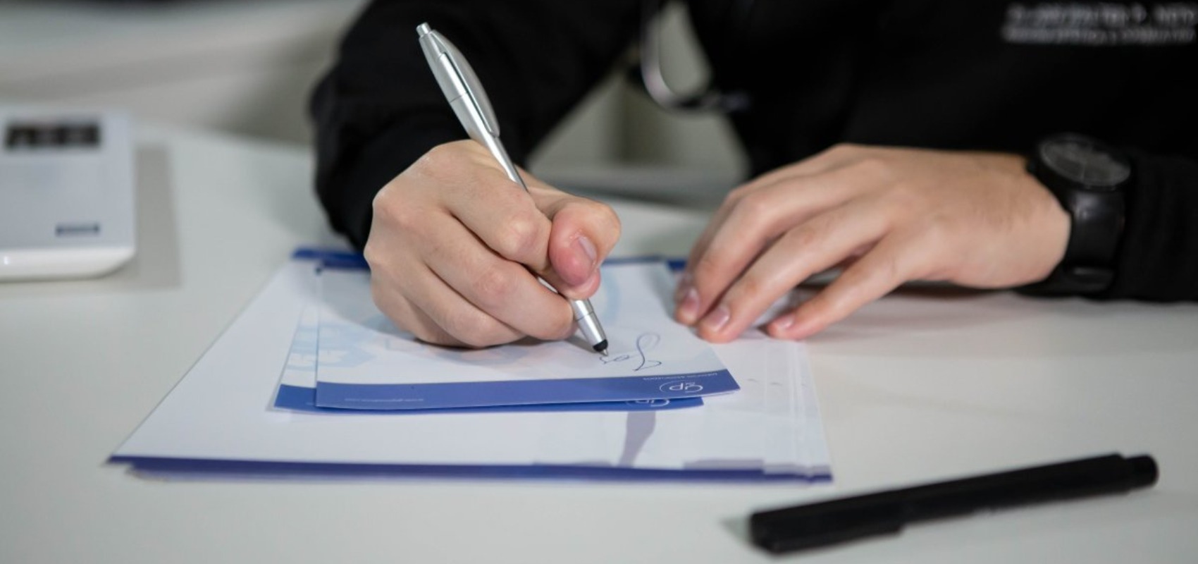 Doctor writing a prescription with a pen in a clinic setting