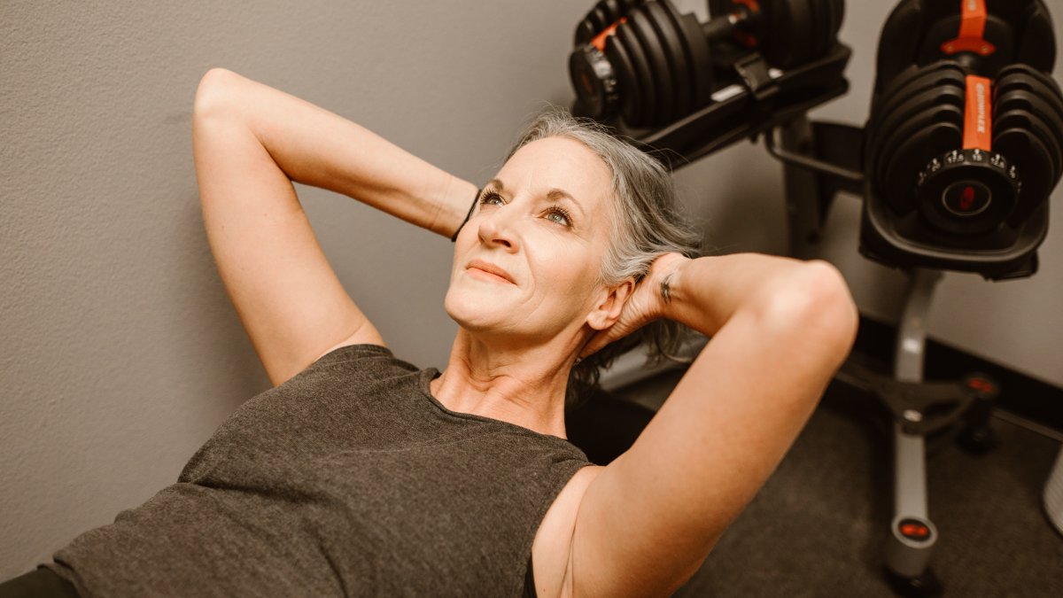 A senior woman exercising with dumbbells promoting active lifestyle and body strength during hormone therapy.