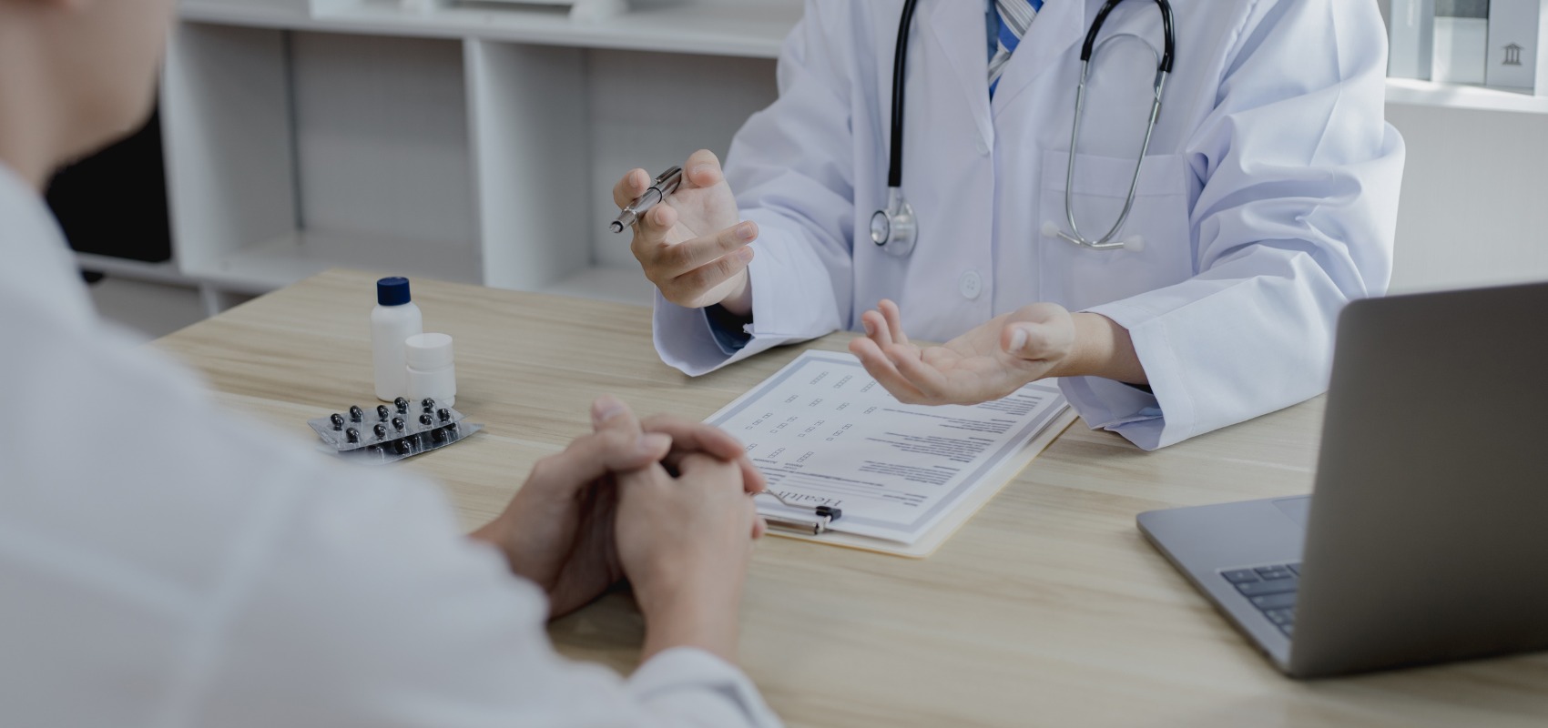 Doctor gesturing with a pen during a medical consultation