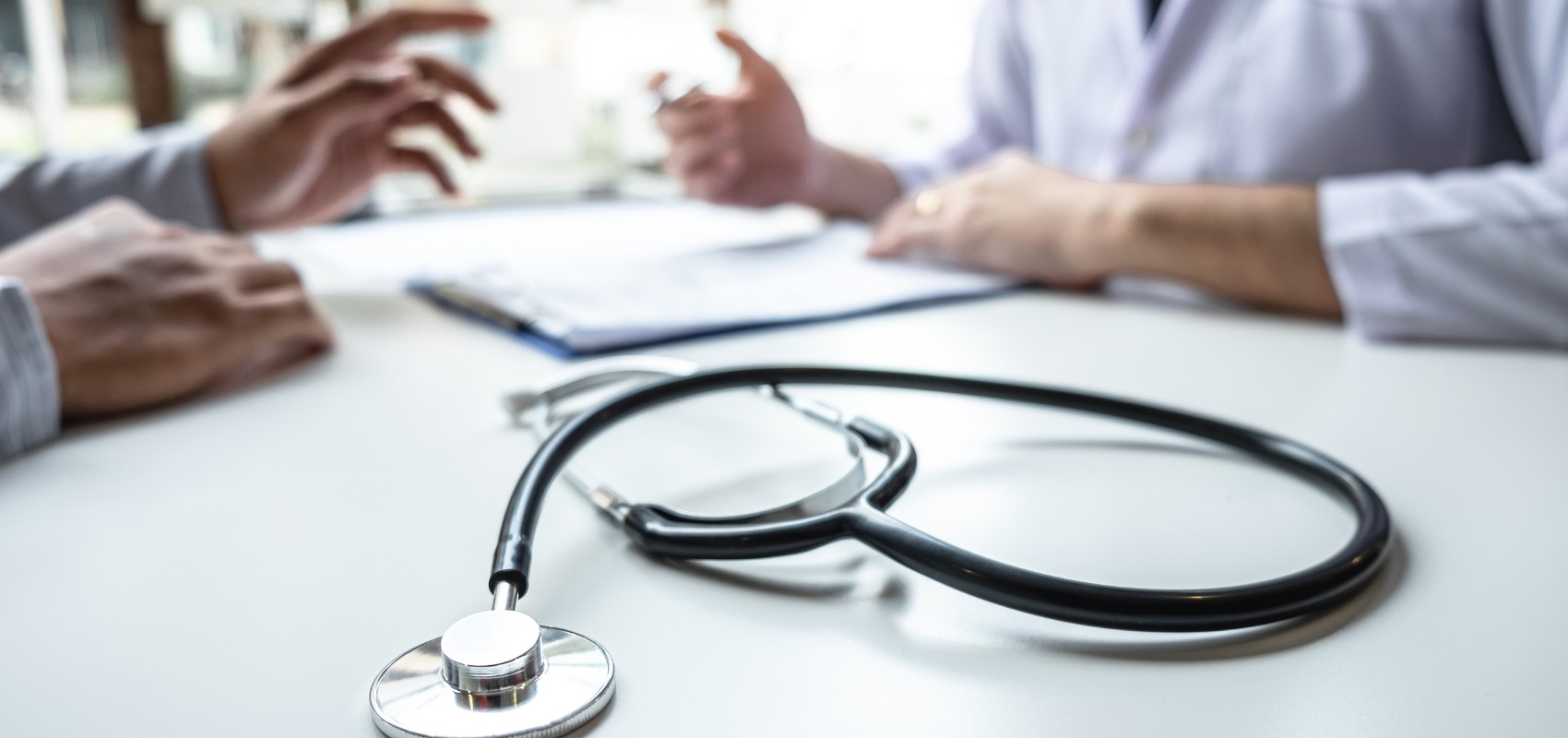 black stethoscope sitting on a white desk