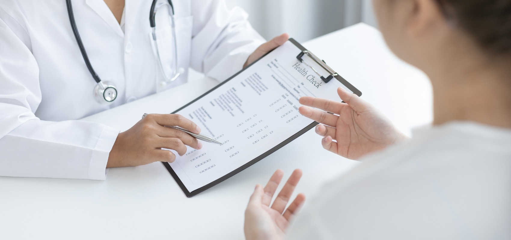 Doctor pointing to health check clipboard