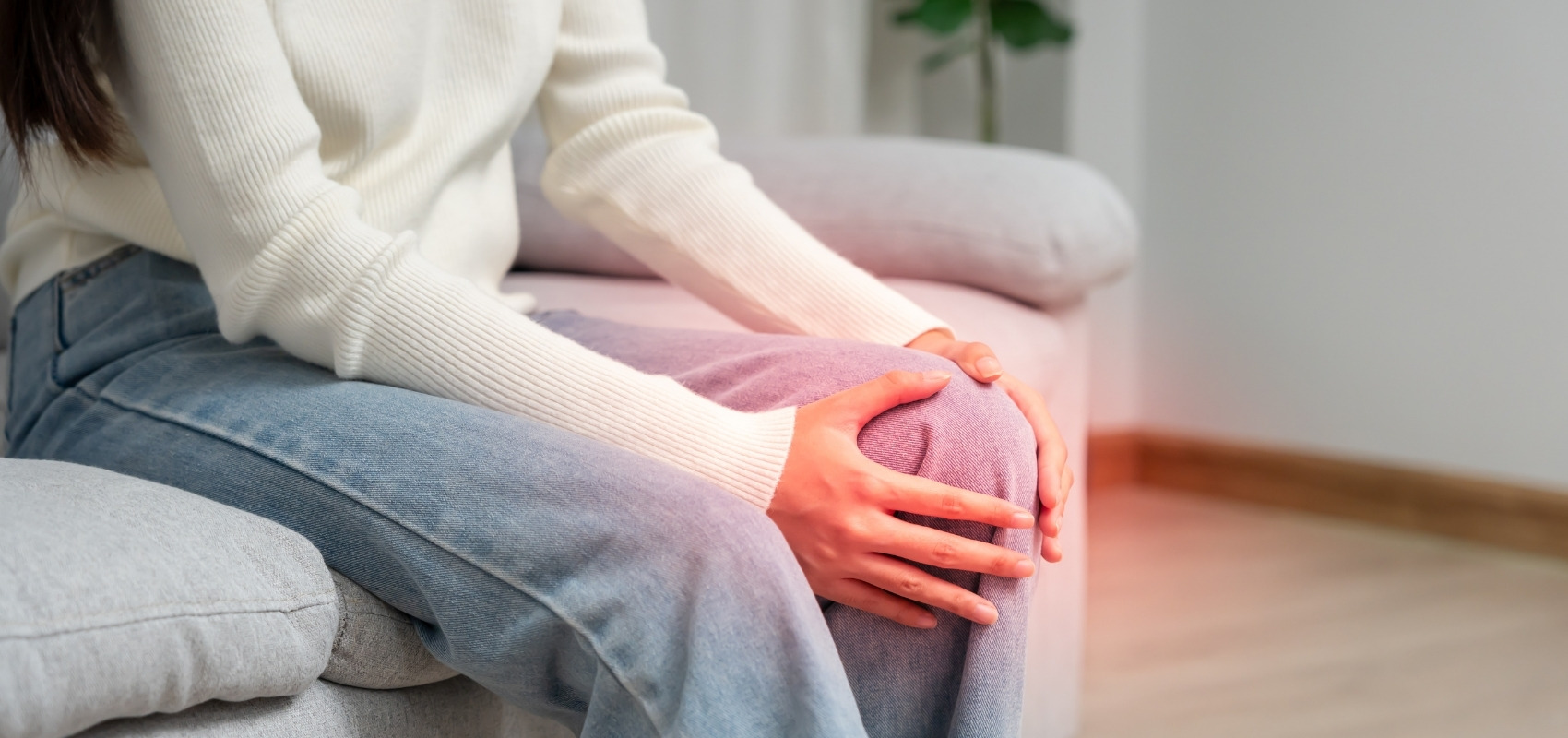 holding her painful, highlighted knee