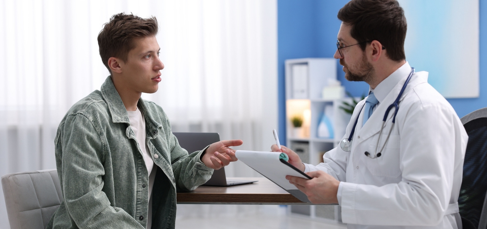 adult male patient sitting across from a physician