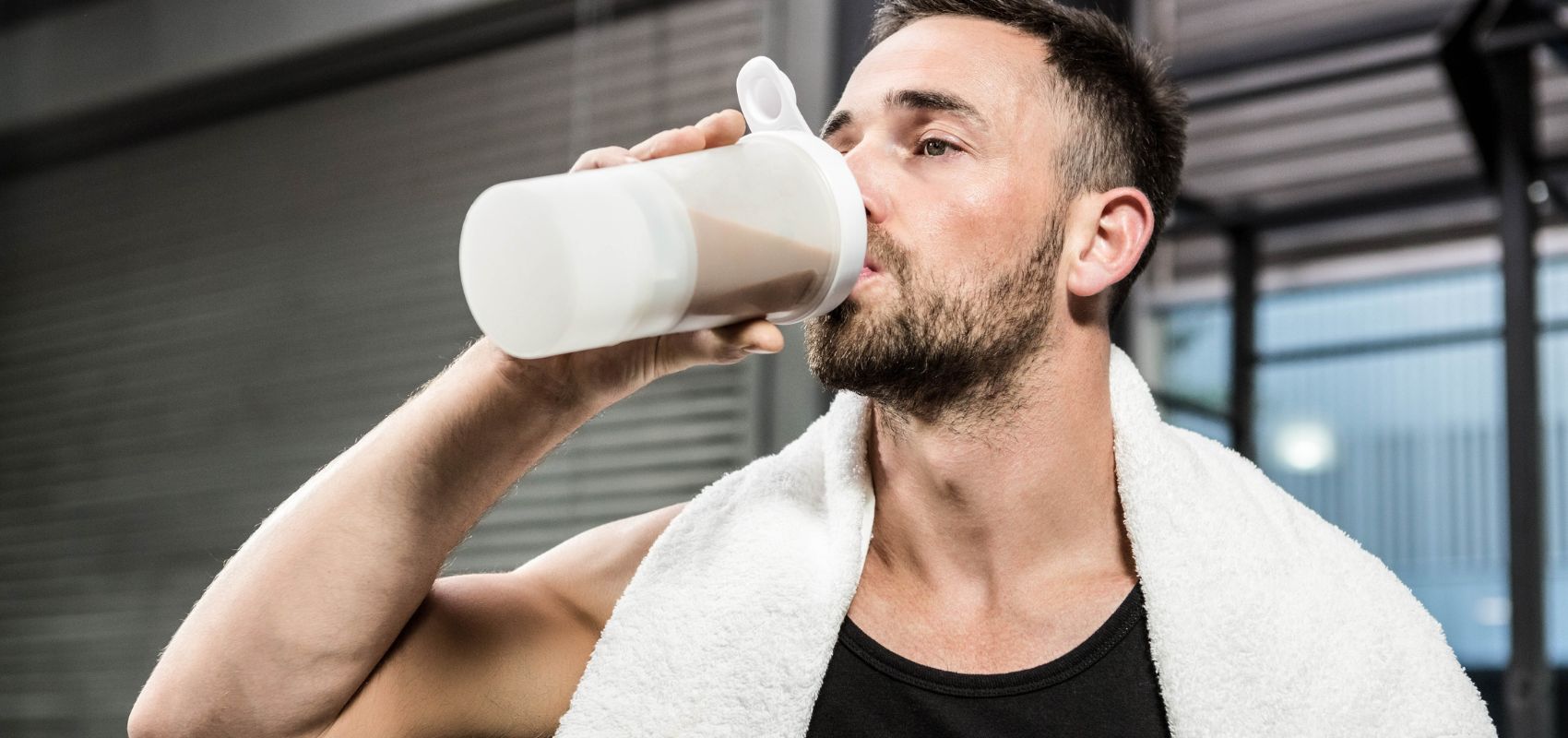 Man drinking a protein shake from a shaker cup