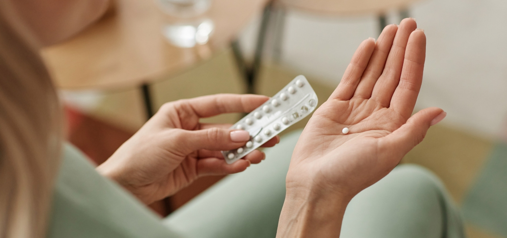 holding a blister pack of birth control pills
