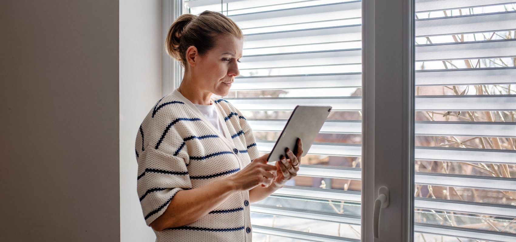 looking at a digital tablet held in her hands