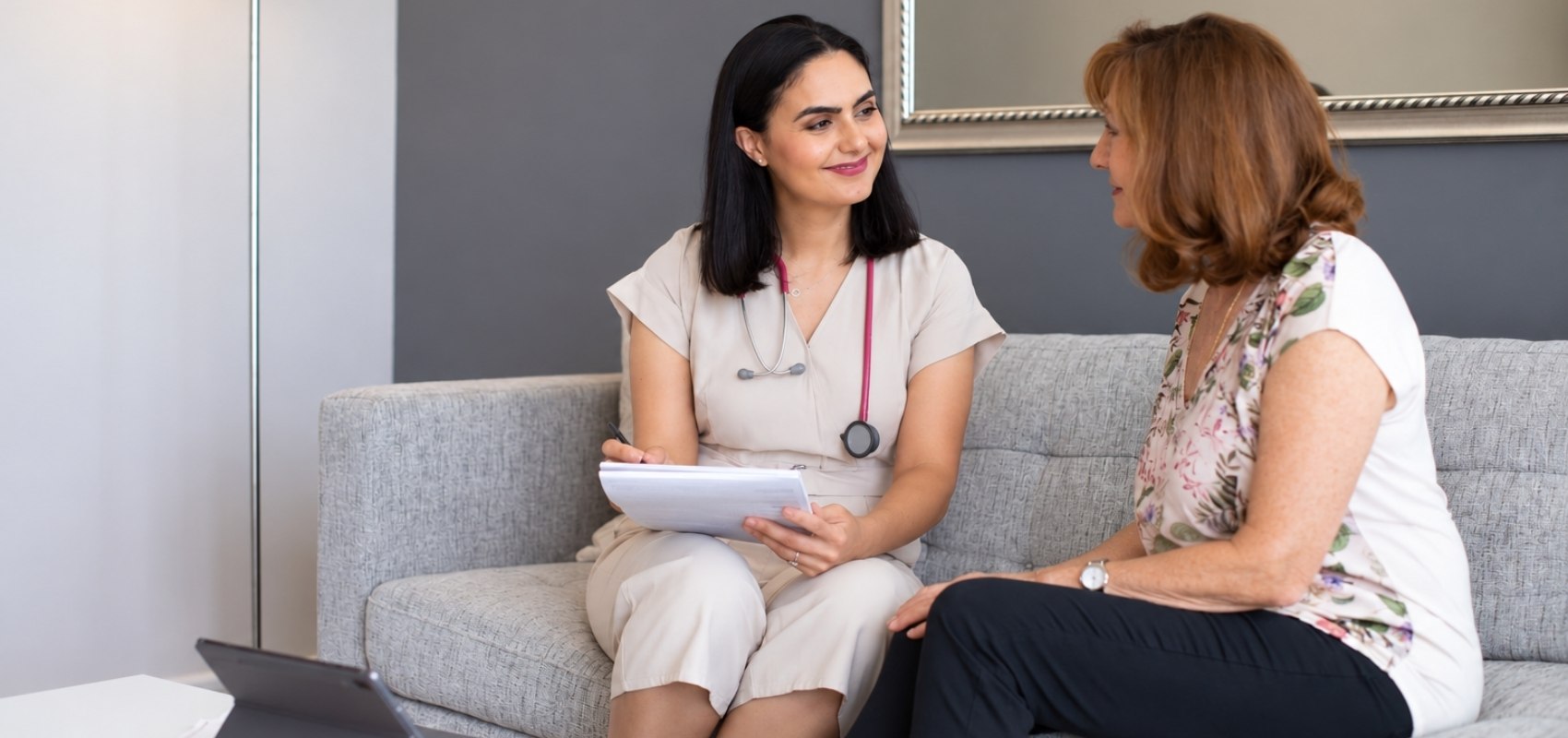 taking notes while consulting with a female patient