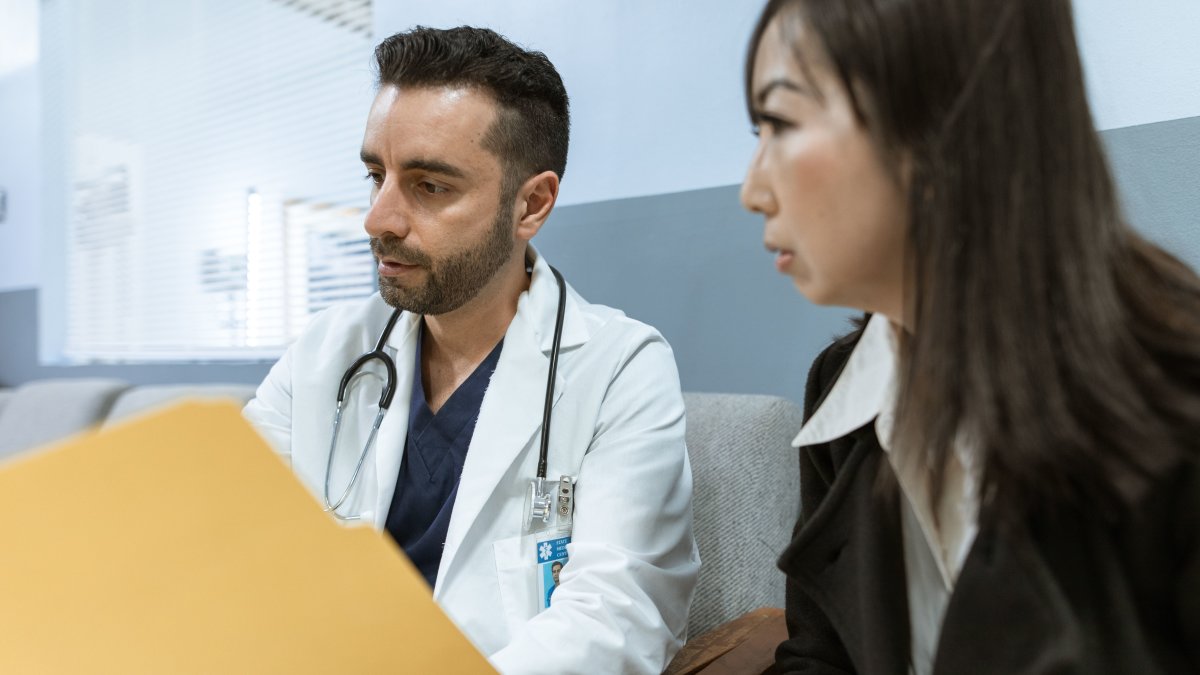 Doctor discussing health records with patient in clinic